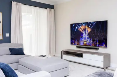 a living room with a couch and a flat screen tv at Stunning 5 Bd w/ Pool Close to Disney 2905 in Kissimmee