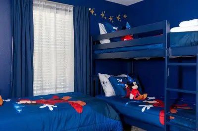 a blue bedroom with two bunk beds and a window at Stunning 5 Bd w/ Pool Close to Disney 2905 in Kissimmee