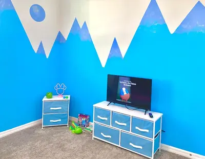a childs room with a blue wall with mountains at 3B2B-Beautiful Lake View-Baby Friendly-FREE WATER PARK!NO Resort Fee-5 Miles to Disney-Storey Lake 3141 in Kissimmee