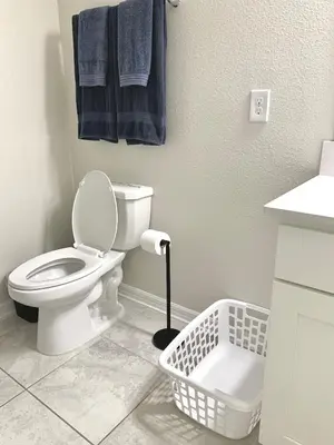 a bathroom with a toilet and blue towels on the wall at 3B2B-Beautiful Lake View-Baby Friendly-FREE WATER PARK!NO Resort Fee-5 Miles to Disney-Storey Lake 3141 in Kissimmee