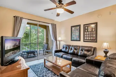 a living room with a couch and a tv at Magical Adventure Condo w Waterpark near Disney No Resort Fees in Orlando