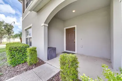 a front door of a house with bushes at 7 Mi Walt Disney World! Family Gem with Private Pool in Kissimmee