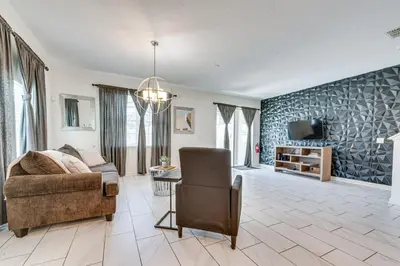 a living room with a couch and a tv at 7 Mi Walt Disney World! Family Gem with Private Pool in Kissimmee