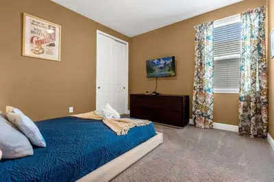 a bedroom with a blue bed and a window at 371P Fabulous 8 BD Private PoolSpa- By Disney in Orlando
