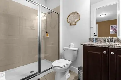 a bathroom with a toilet and a shower and a sink at 371P Fabulous 8 BD Private PoolSpa- By Disney in Orlando
