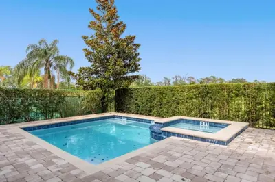 a swimming pool in a backyard with a fence at 371P Fabulous 8 BD Private PoolSpa- By Disney in Orlando