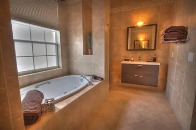 a bathroom with a tub and a window and a sink at Mickeys Getaway - CUSTOM 8BR Luxurious Retreat Pool Hot Tub Theater RM Gym! Outdoor Kitchen 2 Miles to Disney in Orlando