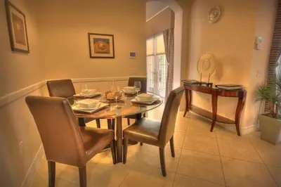 a dining room with a table and chairs at Mickeys Getaway - CUSTOM 8BR Luxurious Retreat Pool Hot Tub Theater RM Gym! Outdoor Kitchen 2 Miles to Disney in Orlando