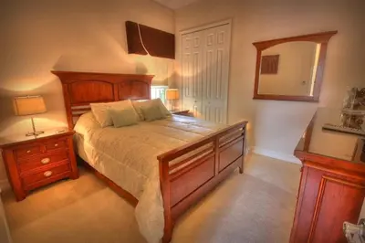 a bedroom with a bed and a dresser and a mirror at Mickeys Getaway - CUSTOM 8BR Luxurious Retreat Pool Hot Tub Theater RM Gym! Outdoor Kitchen 2 Miles to Disney in Orlando