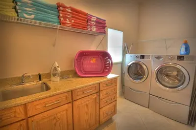 a kitchen with a sink and a washing machine at Mickeys Getaway - CUSTOM 8BR Luxurious Retreat Pool Hot Tub Theater RM Gym! Outdoor Kitchen 2 Miles to Disney in Orlando