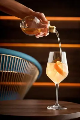 a person pouring a drink into a wine glass at Lake Nona Wave Hotel in Orlando