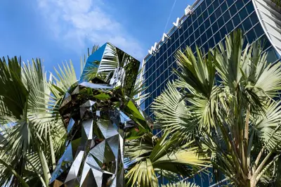 a statue in front of a tall building with palm trees at Lake Nona Wave Hotel in Orlando