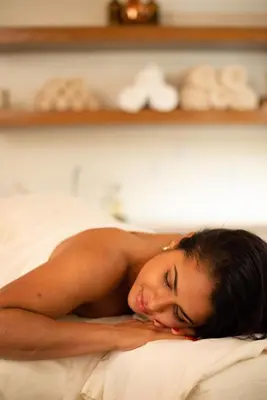 a naked woman laying on a bed with her head on a pillow at Lake Nona Wave Hotel in Orlando