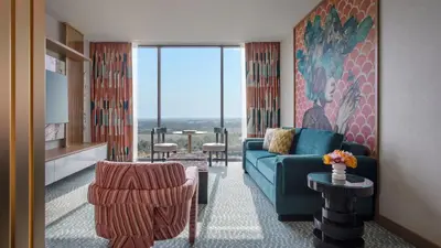 a living room with a couch and chairs and a large window at Lake Nona Wave Hotel in Orlando