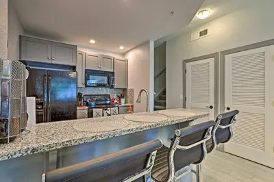 a kitchen with a counter and chairs in a room at 10 Mi to Disney Venetian Bay Villages Retreat in Kissimmee