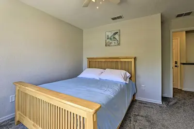 a bedroom with a bed with a wooden headboard at 10 Mi to Disney Venetian Bay Villages Retreat in Kissimmee