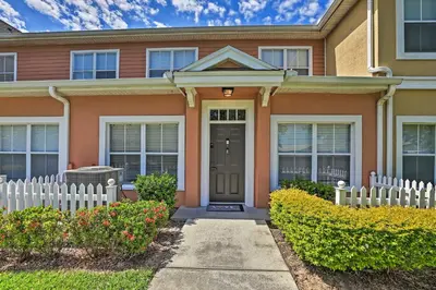 a house with a white fence in front of it at 10 Mi to Disney Venetian Bay Villages Retreat in Kissimmee