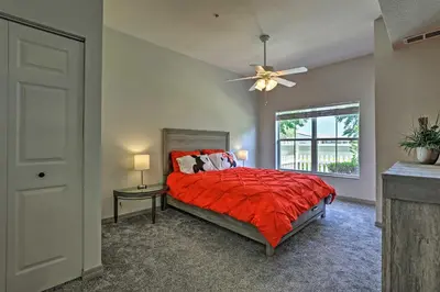 a bedroom with a bed with a red comforter and a window at 10 Mi to Disney Venetian Bay Villages Retreat in Kissimmee