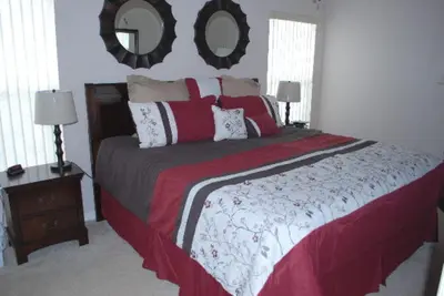 a bedroom with a large bed and a mirror at Luxury 5-Bed Villa, located only 3 miles from Disney World in Kissimmee