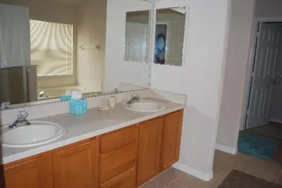 a bathroom with two sinks and a mirror at Luxury 5-Bed Villa, located only 3 miles from Disney World in Kissimmee