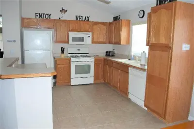 a kitchen with white appliances and wooden cabinets at Luxury 5-Bed Villa, located only 3 miles from Disney World in Kissimmee
