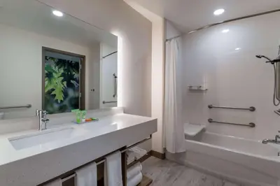 a bathroom with a sink and a tub and a shower at Wyndham Garden Orlando Airport - Free Airport Shuttle in Orlando