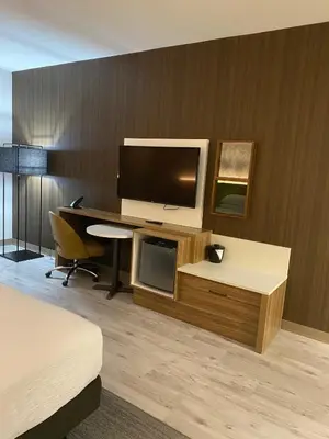 a hotel room with a desk with a computer and a television at Wyndham Garden Orlando Airport - Free Airport Shuttle in Orlando