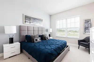 a bedroom with a bed with a blue comforter at Summerville Resort 4 Bedrooms Villa in Orlando