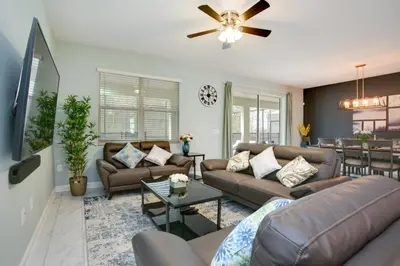 a living room with a couch and a table at 9 Bed Storey Lake Resort Game Room Pool home in Kissimmee
