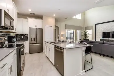 a large kitchen with white cabinets and stainless steel appliances at Boutique Style Home Near Disney! home in Kissimmee