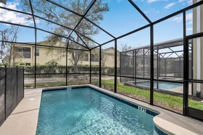 a swimming pool in a house with glass walls at Boutique Style Home Near Disney! home in Kissimmee