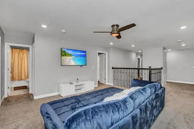 a blue couch in a living room with a ceiling fan at Storey Lake Resort 9 Bed Game Theater Room home in Kissimmee