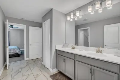 a bathroom with two sinks and a large mirror at Storey Lake Resort 9 Bed Game Theater Room home in Kissimmee