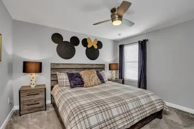 a bedroom with a bed and a ceiling fan at Storey Lake Resort 9 Bed Game Theater Room home in Kissimmee