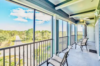 a balcony with two chairs and a view of the water at Stunning 3BR Near Disney - Pool in Orlando