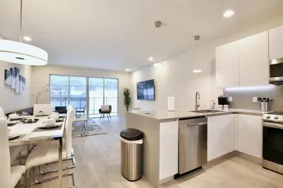a kitchen and living room with a table and chairs at High luxury 3 bedroomloft townhouse in Hidden Forest, with private pool! in Orlando