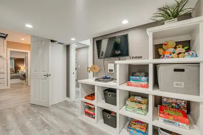a living room with white shelves and a tv at Family Home with Private Pool 24 Mi to Disney! in Saint Cloud