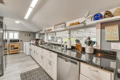 a large kitchen with white cabinets and stainless steel appliances at Family Home with Private Pool 24 Mi to Disney! in Saint Cloud