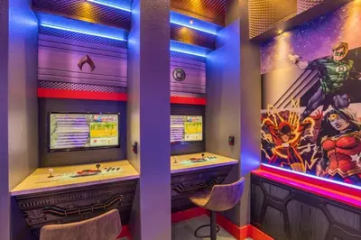 a room with a bar with a superhero painting on the wall at Amazing Game Room Your Kids Will Love! villa in Kissimmee