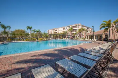 a swimming pool with lounge chairs and an umbrella at Vista Cay Resort by Millenium at Universal Blvd. in Orlando