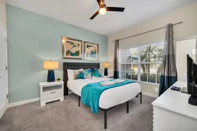 a bedroom with a bed and a desk and a television at Spacious and Luxurious Home With Splash Pool, Close to Disney #4ST804 in Kissimmee