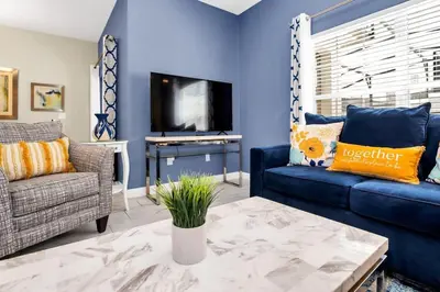 a blue living room with a couch and a tv at Spacious and Luxurious Home With Splash Pool, Close to Disney #4ST804 in Kissimmee