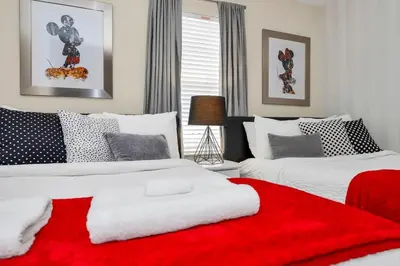 a bedroom with two beds with a red blanket at Spacious and Luxurious Home With Splash Pool, Close to Disney #4ST804 in Kissimmee