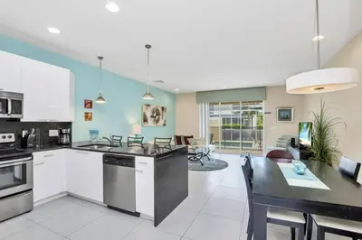 a kitchen with white cabinets and a dining room at 3 bed Town Home With Splash Pool! townhouse in Orlando