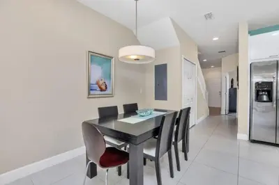 a dining room with a black table and chairs at 3 bed Town Home With Splash Pool! townhouse in Orlando