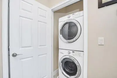 a laundry room with a washer and dryer next to a door at 3 bed Town Home With Splash Pool! townhouse in Orlando