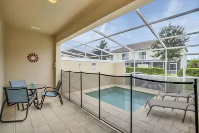 a balcony with a pool and a table and chairs at 3 bed Town Home With Splash Pool! townhouse in Orlando