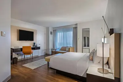 a hotel room with a large bed and a desk at Marriott Orlando Downtown in Orlando