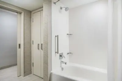 a white bathroom with a shower and a tub at Courtyard by Marriott Orlando Downtown in Orlando
