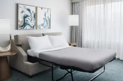 a hotel room with a bed and a couch at Courtyard by Marriott Orlando Downtown in Orlando